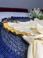 Close-up of a blue and gold fabric with decorative elements on a dark background