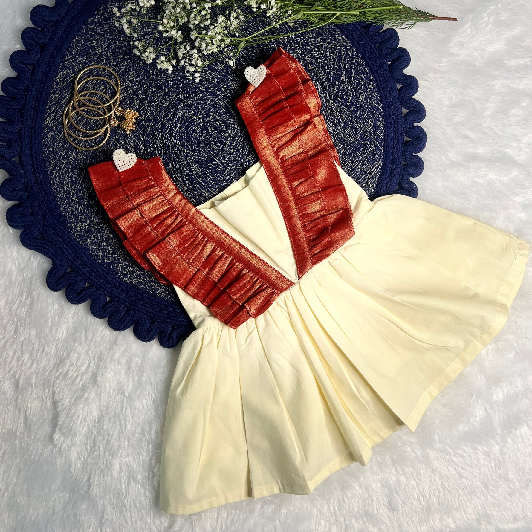 white ethnic skirt with jewelry and flowers on a textured surface