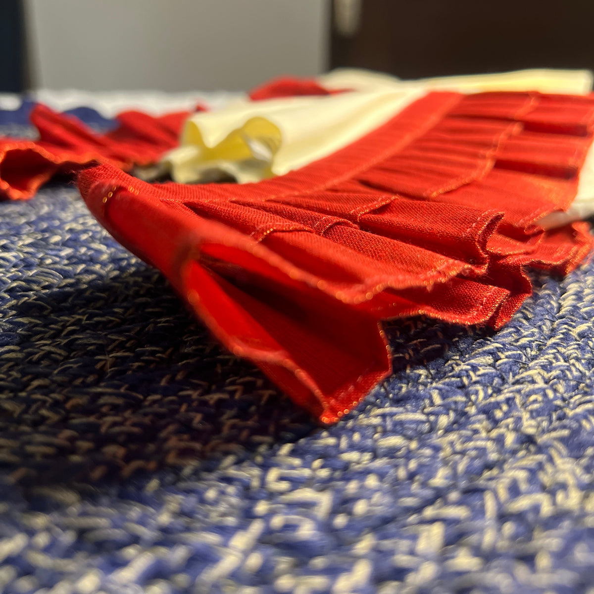 Close-up of a folded red frock on a blue patterned surface