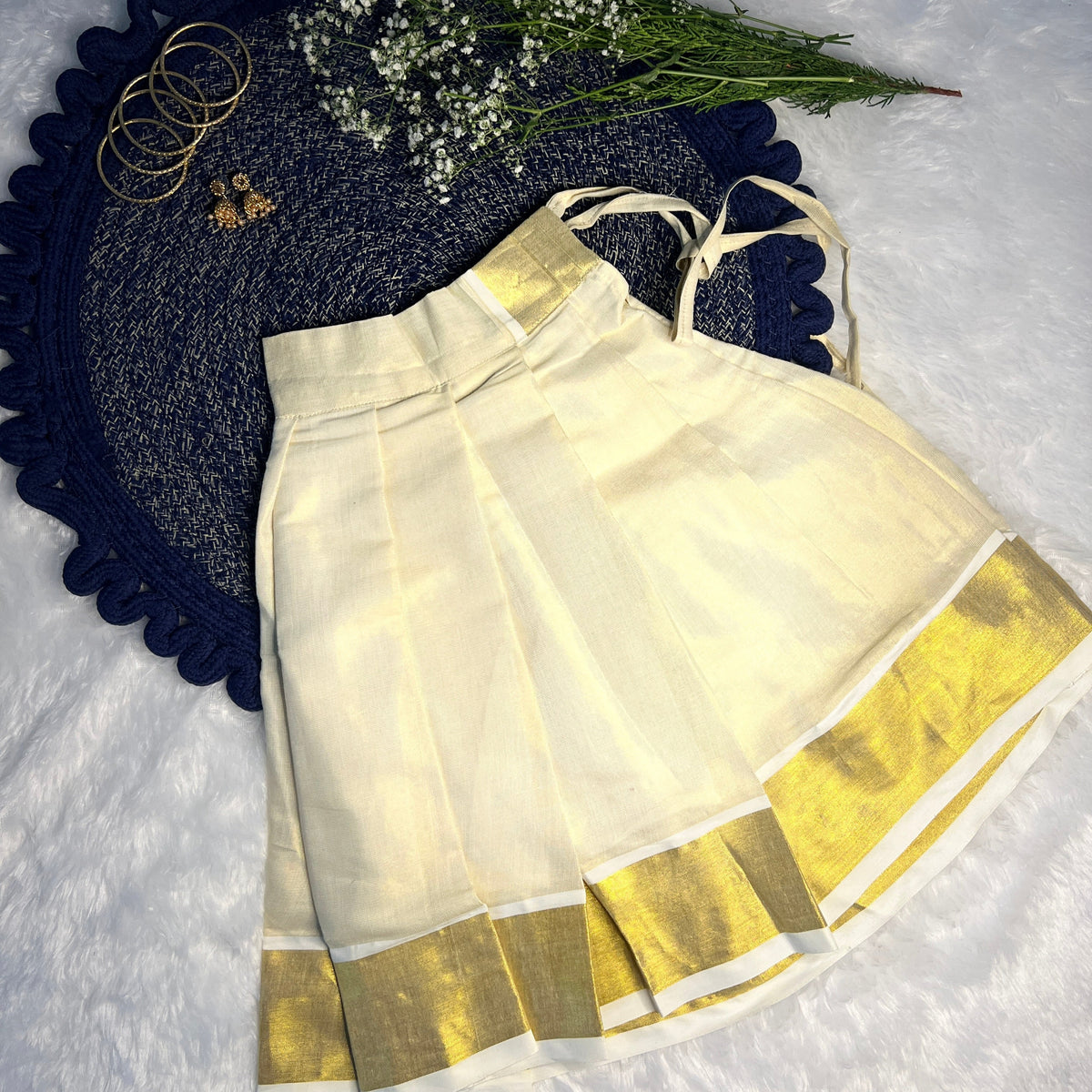 White girls skirt with gold border on a textured surface