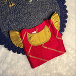 red and gold top girl dress, navy border, and white flowers on a textured white background