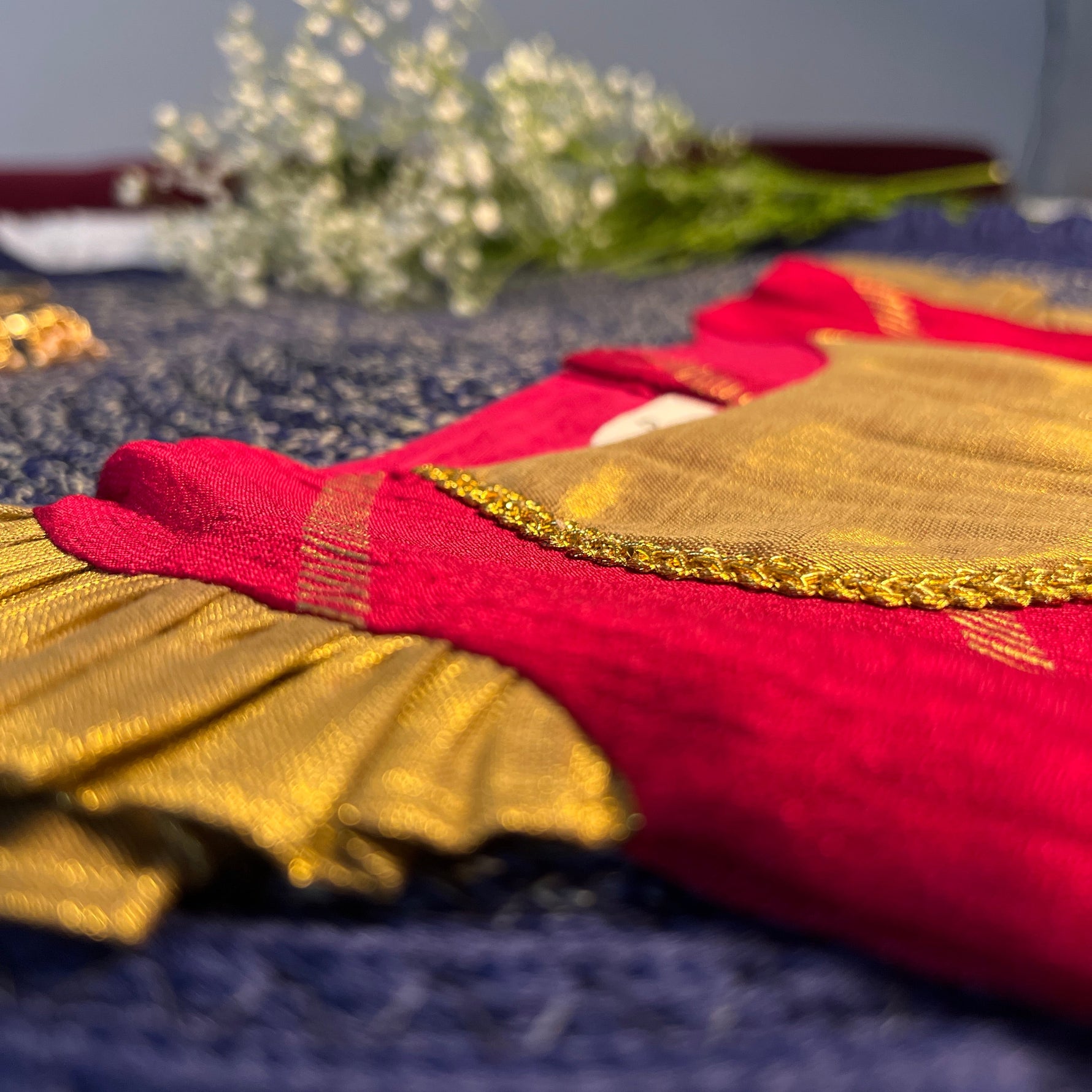 Close-up of a red and gold fabric with floral background