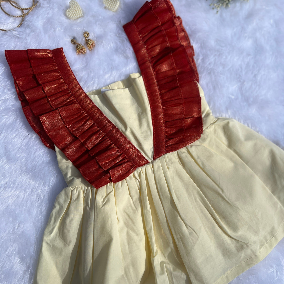 Beige dress with red ruffled top on a light gray background