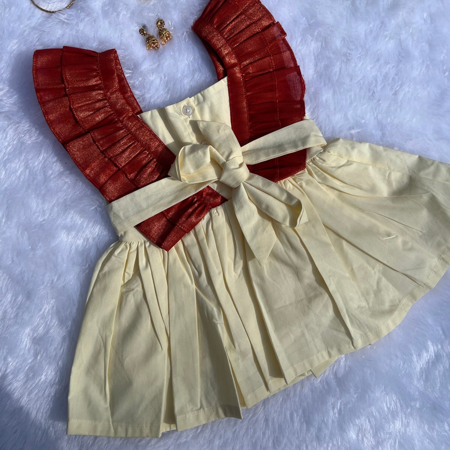 Beige dress with red accents and accessories on a textured surface