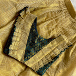 Close-up of a green top with gold skirt with intricate patterns baby dress