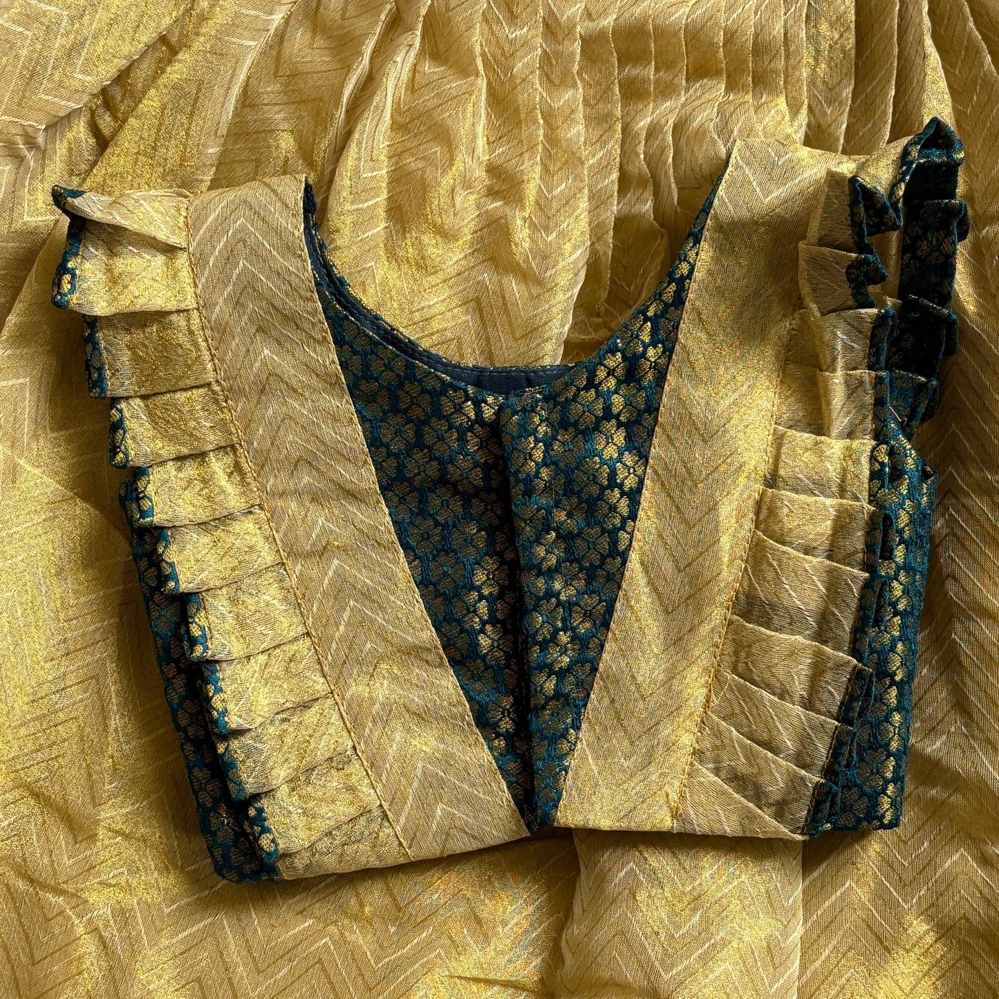 Close-up of a green top with skirt yellow fabric with intricate patterns and textures.