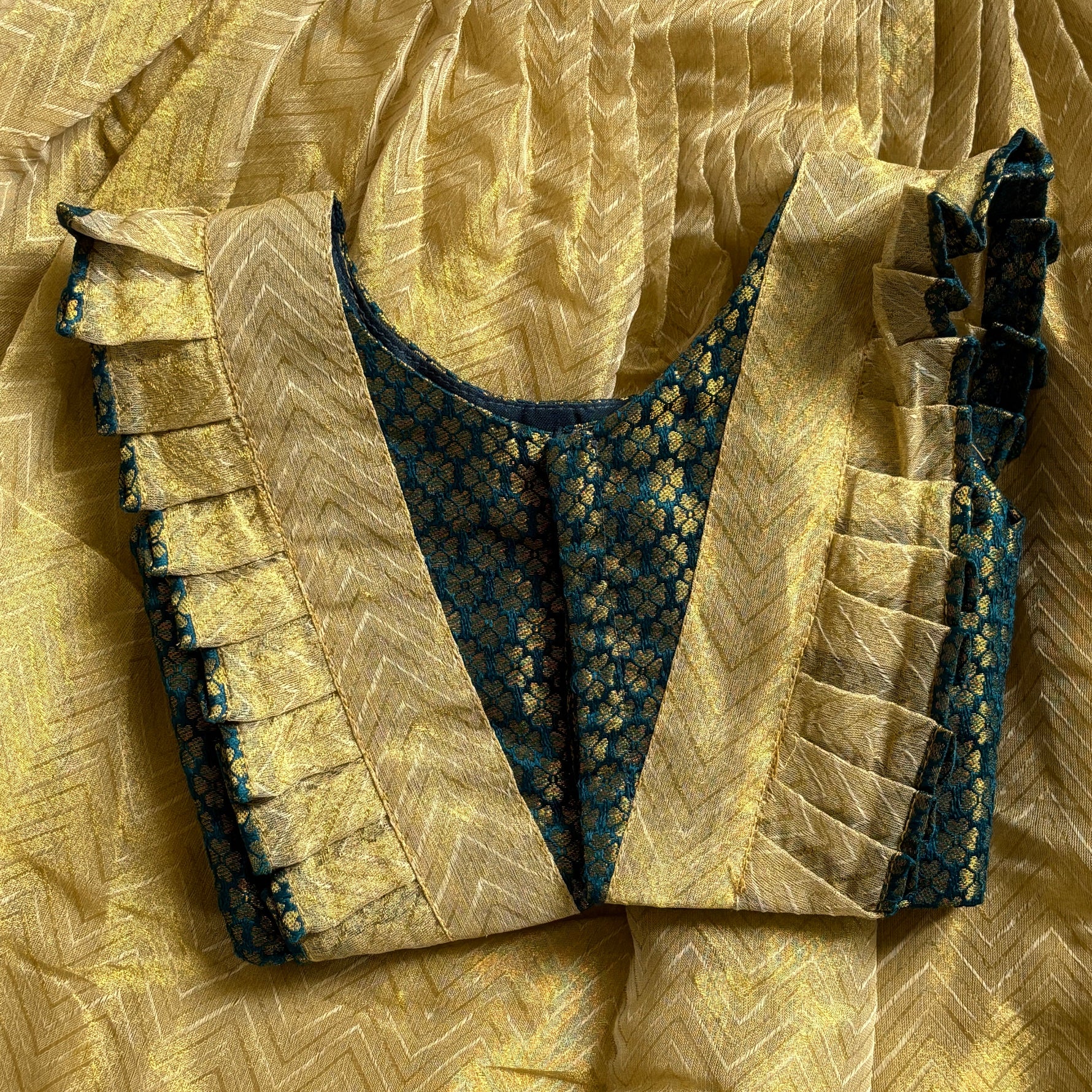 Close-up of a green top with skirt yellow fabric with intricate patterns and textures.